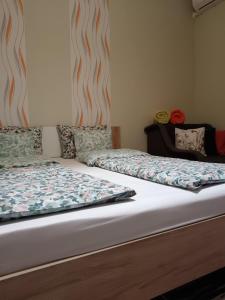 dos camas sentadas una al lado de la otra en un dormitorio en Hársfa apartman, en Makó