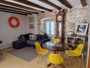 a living room with a couch and a table and chairs at Villa Kata in Rab