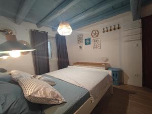 a bedroom with a bed and a chandelier at Villa Kata in Rab