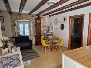 a living room with a table and yellow chairs at Villa Kata in Rab +15 photos