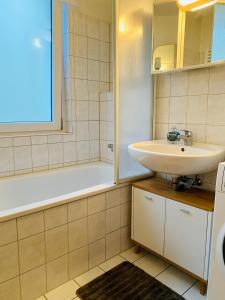 ein weißes Badezimmer mit einem Waschbecken und einer Badewanne in der Unterkunft Moderne Unterkunft in Garbsen