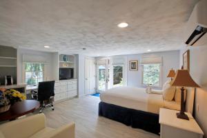 a bedroom with a bed and a desk with a computer at Pleasant Bay Village Resort in Chatham