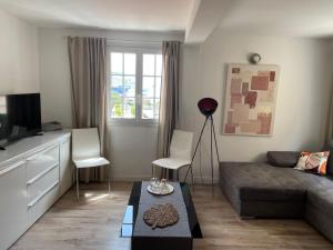a living room with a couch and a table at Appartement Vue mer Centre ville in Ajaccio