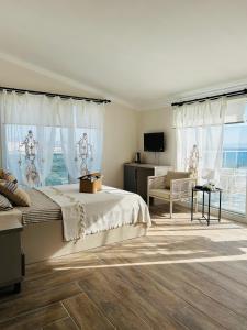 a bedroom with a large bed and a television at Soho Ayvalık Beach House in Kucukkoy