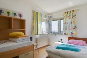a bedroom with two beds and two windows at Vila Ida in Zagreb