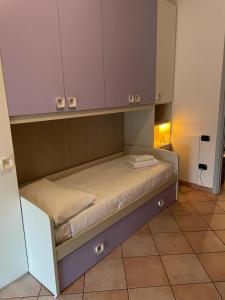 a small bed in a room with a cabinet at Burago Flat in Burago di Molgora