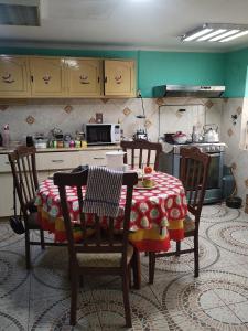 una cocina con mesa y sillas y una cocina con paredes verdes. en Casa Sánchez en Huancayo