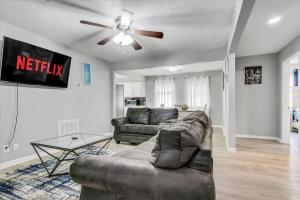 a living room with a couch and a ceiling fan at Comfy 3 bedroom home w/ fenced yard in Bridge City