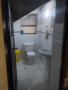 y baño con aseo y lavamanos. en Casa Sánchez, en Huancayo