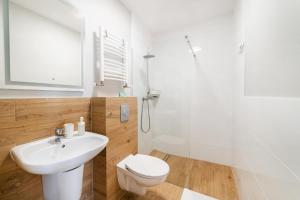 een badkamer met een toilet, een wastafel en een douche bij Apartamenty Białe Piaski in Jastarnia +59 foto's