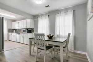 a kitchen with a dining room table and chairs at Comfy 3 bedroom home w/ fenced yard in Bridge City