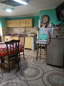 cocina con nevera y mesa. en Casa Sánchez en Huancayo