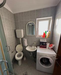 baño pequeño con lavadora y lavamanos en Modern and homely family house., en Cetinje