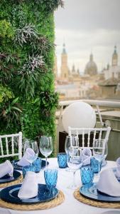 una mesa con copas de vino y servilletas. en Aparthotel Los Girasoles, en Zaragoza