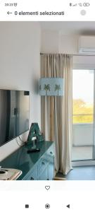 a bathroom with a desk with a mirror and a window at Bellavista Punta Ala in Punta Ala