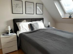 HagenburgにあるTop Ferienwohnung „Am Schloß“ für 4-6 Gästeのベッドルーム1室(壁に3枚の写真が飾られたベッド1台付)