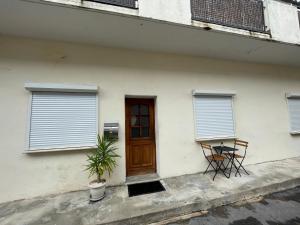 ein Haus mit einer Tür, einem Tisch und einem Stuhl in der Unterkunft Maison « l’effet-mère »en rez de chaussée  in Aigues-Mortes