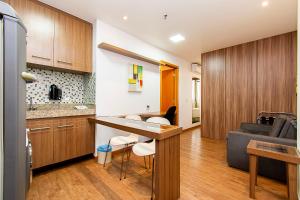 a kitchen and living room with a table and a couch at GS Properties - Nobile Monumental in Brasilia
