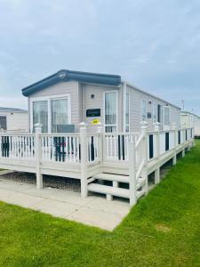 a mobile home with a porch and white railing at Golden Sands, Ingoldmells, 6 berth in Ingoldmells