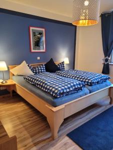 a bedroom with two beds and a blue wall at daZwischen Übernachten in Kammerforst