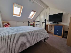 1 dormitorio con 1 cama y TV de pantalla plana en Spacious 3bed semi/Gamesroom/Drive/10mins to City en Wrexham