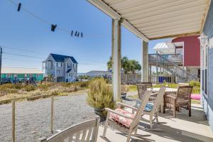 a patio with a table and chairs on a beach at Ocean-View Apt in Emerald Isle - Walk to Beaches! in Emerald Isle