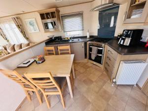 a kitchen with a table and chairs in a caravan at Golden Sands, Ingoldmells, 6 berth in Ingoldmells