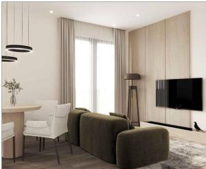uma sala de estar com um sofá, uma mesa e uma televisão em Sea La Vie Apartment em Golem