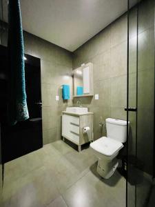 a bathroom with a toilet and a sink and a shower at Cantinho Gute Nacht 3 in Pomerode