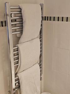 a stack of towels on a towel rack in a bathroom at The Gungate in Tamworth