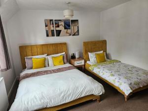 a bedroom with two beds with yellow pillows at The Gungate in Tamworth