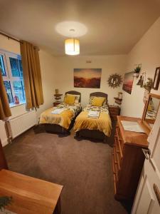a bedroom with two beds and a table and a dresser at Holme Lea, Ingleton, North Yorkshire in Ingleton 