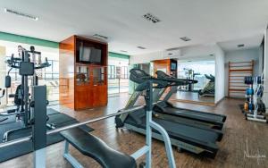 een fitnessruimte met 2 loopbanden en een televisie bij Flat - Comfort Hotel - Taguatinga in Brasilia