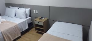 ブラジリアにあるFlat - Comfort Hotel - Taguatingaのベッド2台が備わる小さな客室です。 寝台