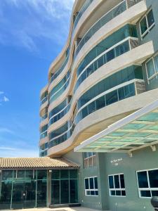 un gran edificio con una fachada curva con ventanas en Novo quarto e sala - J. Armação - Vista Mar!, en Salvador