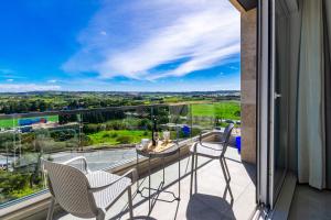 a balcony with chairs and a table with a view at New Spacious Apartment 3 Bdr 2 Bth Bugibba in St Paul's Bay