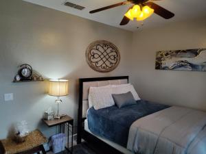 um quarto com uma cama e uma ventoinha de tecto em Buena Vista home em Visalia