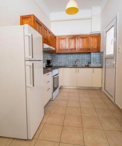 a kitchen with white appliances and wooden cabinets at Cozy Apartment in Hermoupolis in Ermoupoli