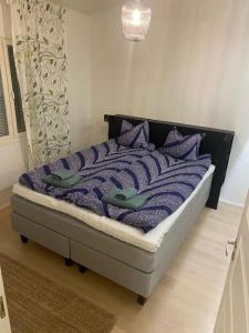 Una cama con almohadas moradas en un dormitorio en 2BR and LuxurySauna, en Tornio