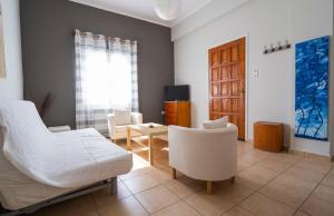 a bedroom with a bed and two chairs and a table at Cozy Apartment in Hermoupolis in Ermoupoli