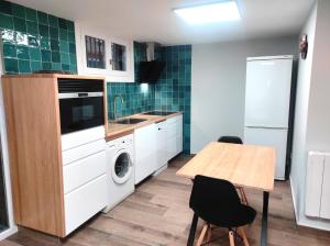 uma cozinha com uma mesa, um lavatório e uma máquina de lavar roupa em CASA Loft Argoños em Argoños