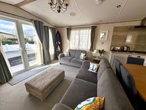sala de estar con sofá y mesa en The Boat House, Hot Tub Lodge, en South Cerney