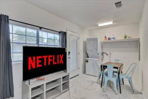 een woonkamer met een televisie en een tafel en stoelen bij Stylishly Remodeled 2-Bedroom home in Orangefield in Orange
