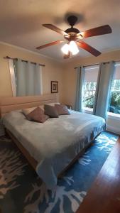 een slaapkamer met een groot bed en een plafondventilator bij Florida Vacation House - Pensacola East Hill in Pensacola