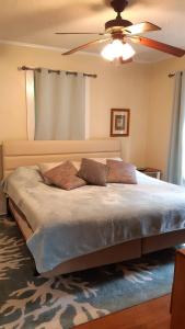 a bedroom with a large bed with a ceiling fan at Florida Vacation House - Pensacola East Hill in Pensacola