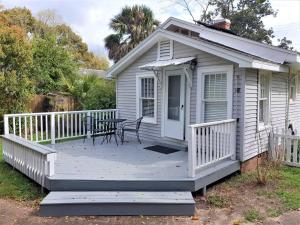 a small white house with a table on a deck at Florida Vacation House - Pensacola East Hill in Pensacola