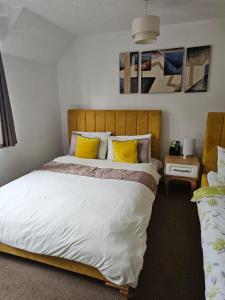 a bedroom with a large bed with yellow pillows at The Gungate in Tamworth