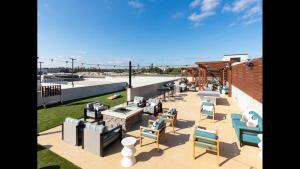 un patio con sillas y mesas en la azotea en Buckhead Quarters- Pool and Private Balcony, en Atlanta