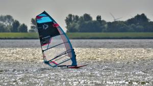 a person is windsurfing on a body of water at Camping Wad noch Meer in Anna Paulowna