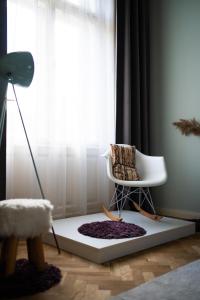 a living room with a white chair and a rug at Modern, design lakás a Margit-sziget mellett in Budapest